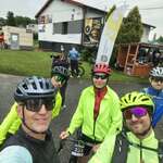Grupa rowerzystów ubranych na zielono, oczekująca na start wyścigu