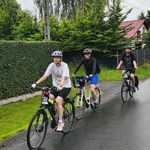 trójka rowerzystów jadąca po ulicy
