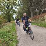 grupa rowerzystów na drodze szutrowej